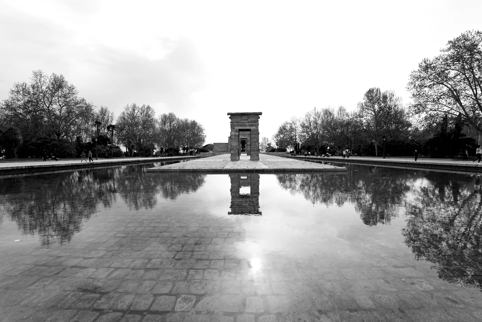 The ancient Egyptian Templo de Debod reflected in its pool in a Madrid park, in black and white, Spain