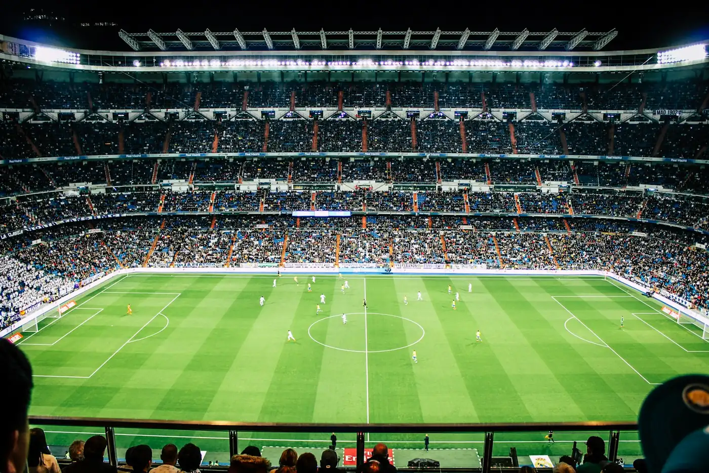 A packed football stadium crowd with white flags on a matchday in Madrid
