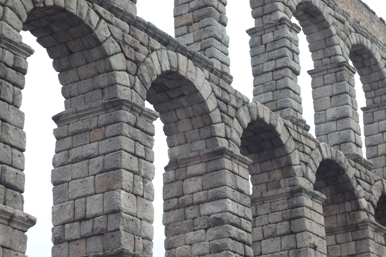 The Roman aqueduct of Segovia, a day trip from Madrid, its unmortared granite arches spanning the old town square