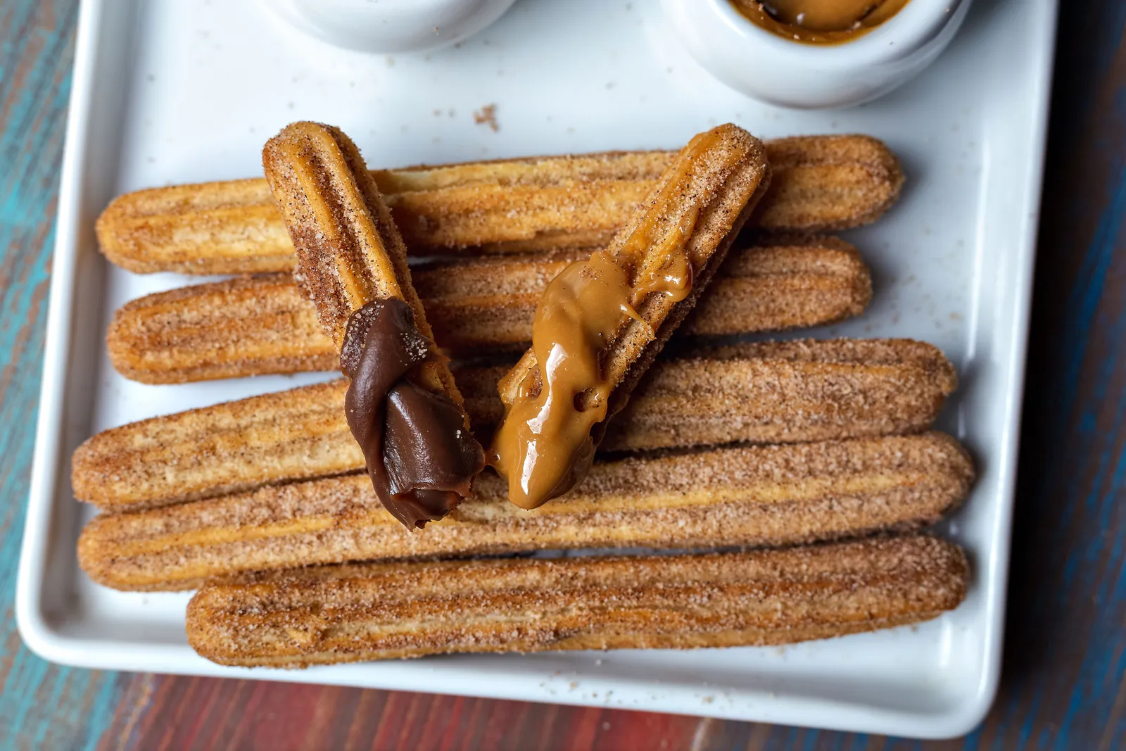A plate of churros with dipping chocolate and dulce de leche in Madrid, Spain