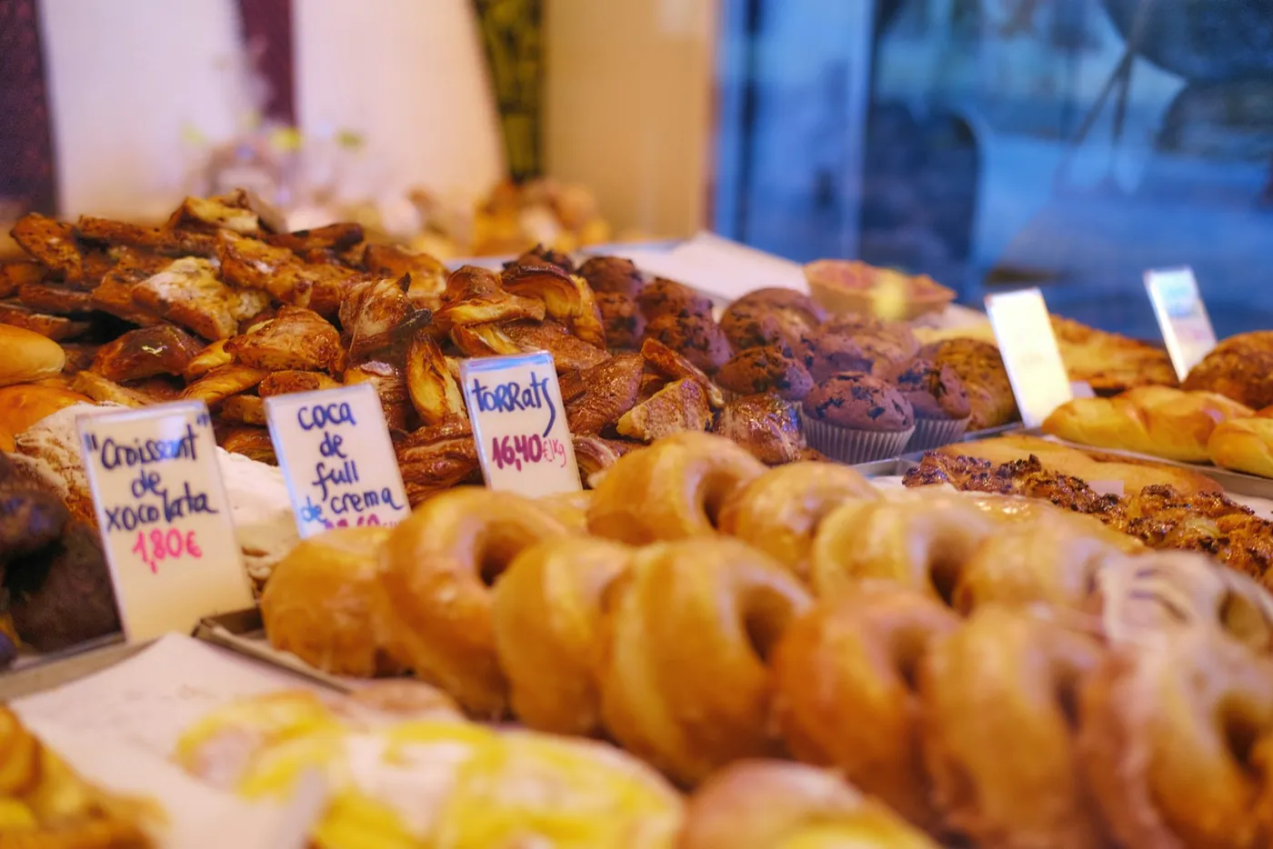 A tray of doughnuts and pastries in a Spanish bakery window