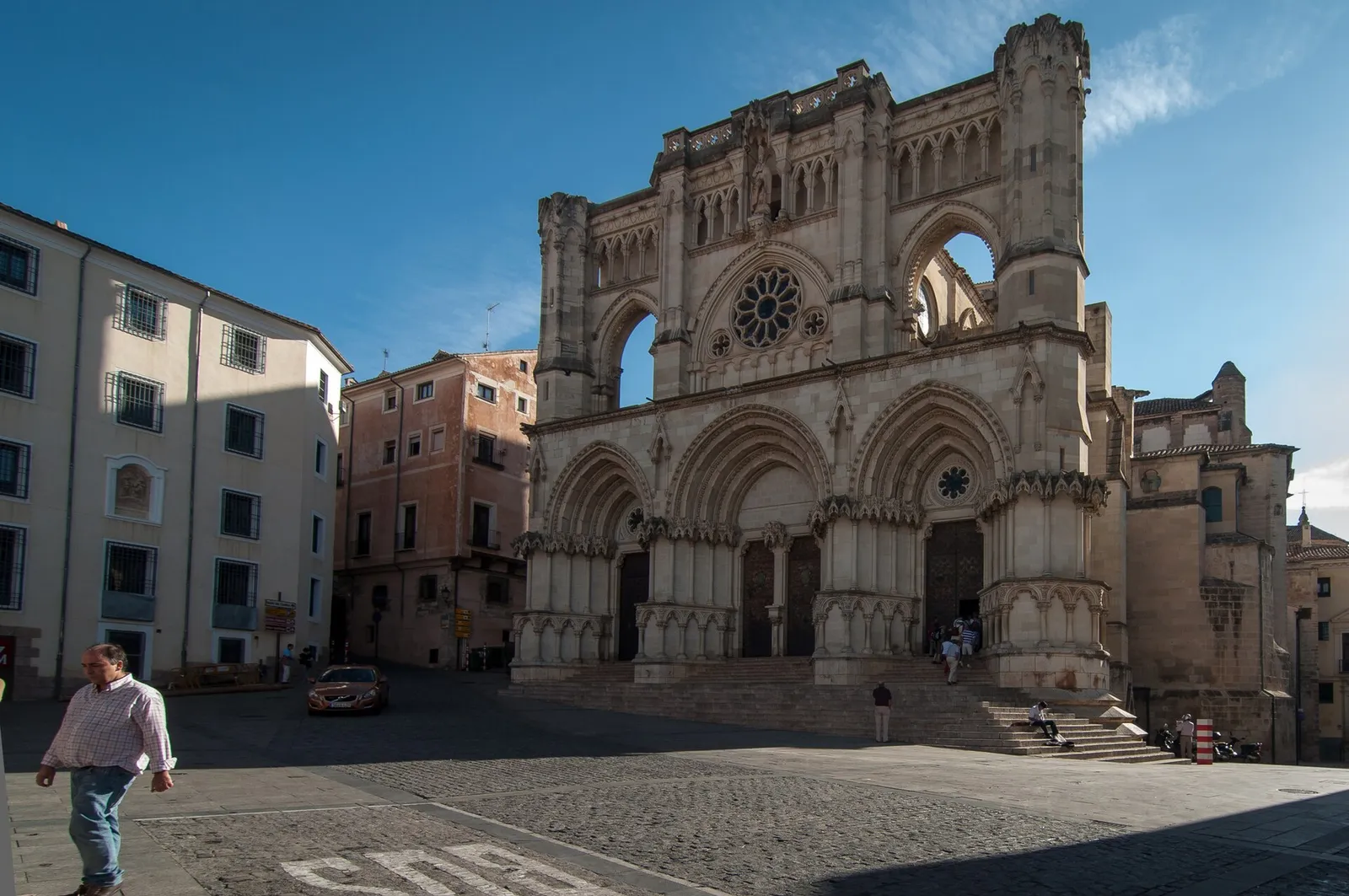 The stone facade of Cuenca cathedral above the arcaded main square, Spain