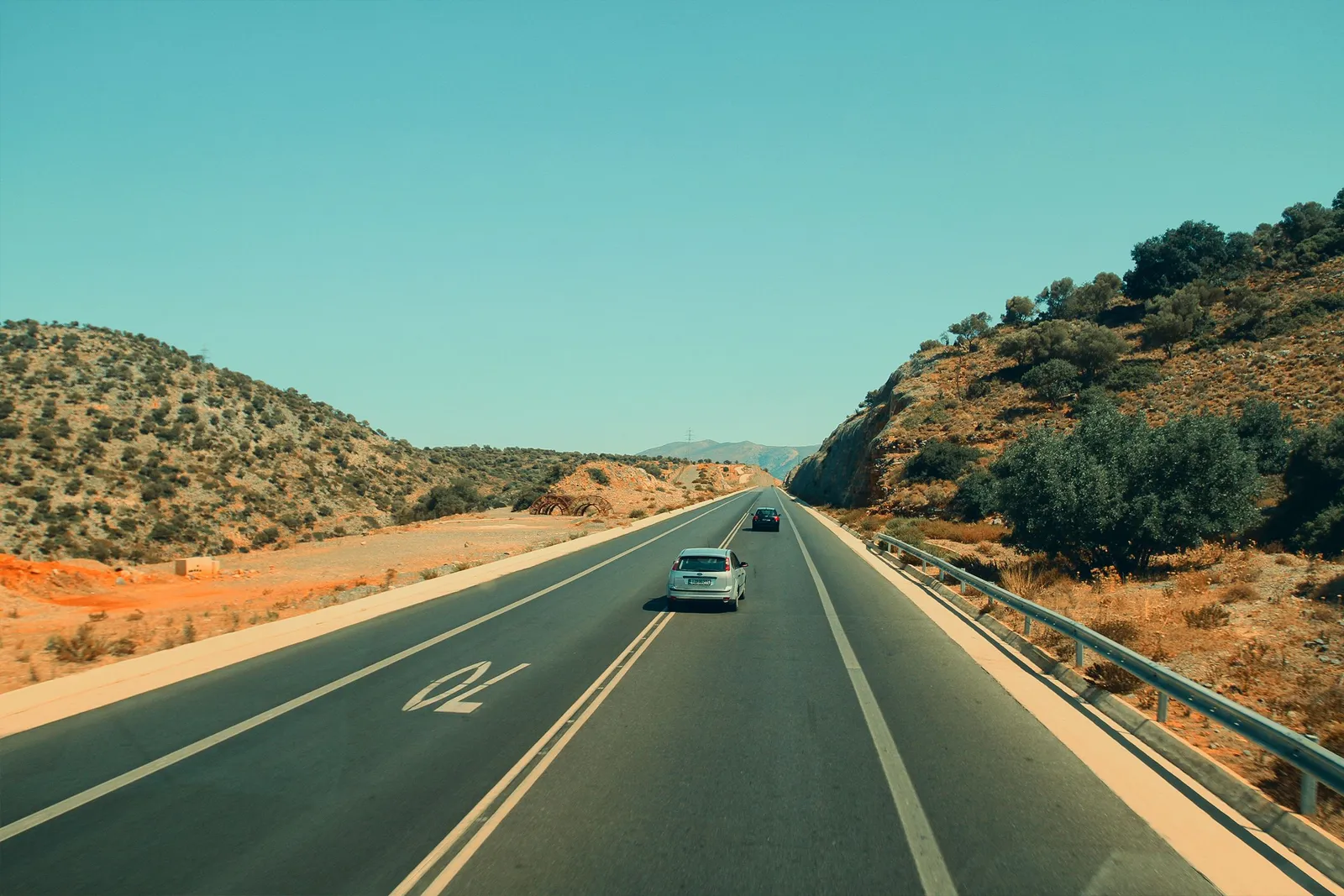 a car on a wide motorway crossing open dry plains in central Spain on a sunny day