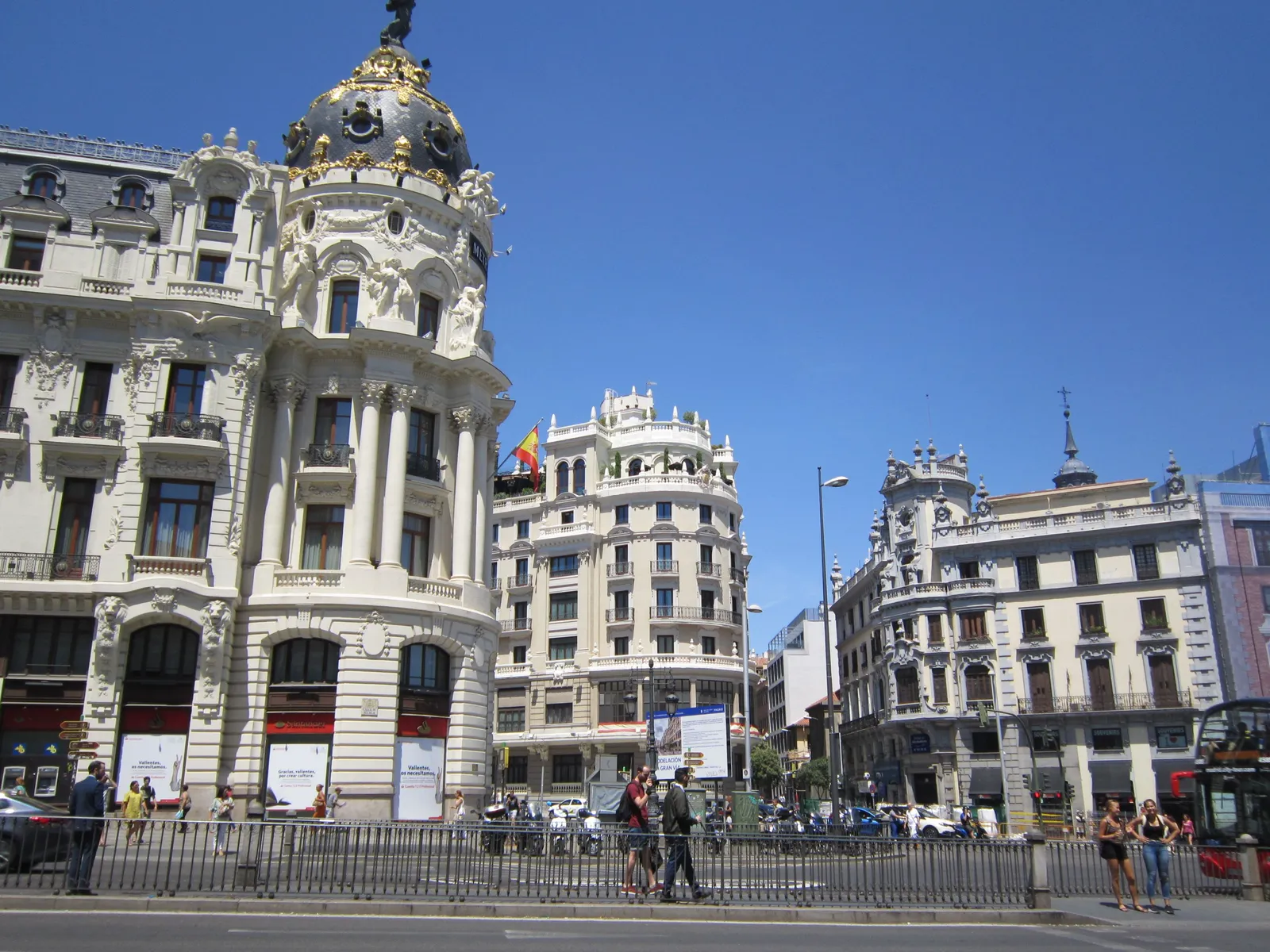 The Gran Via in central Madrid, Spain, with traffic and pedestrians on a bright day