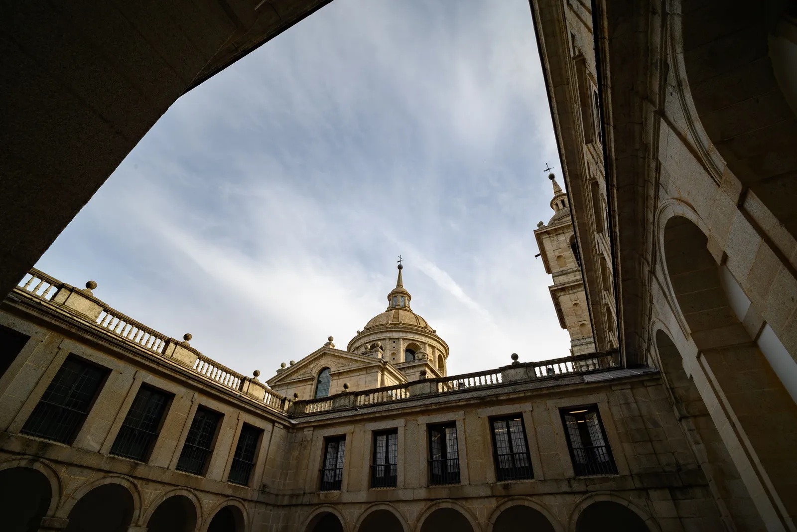 An inner courtyard of El Escorial with the basilica dome behind, near Madrid, Spain