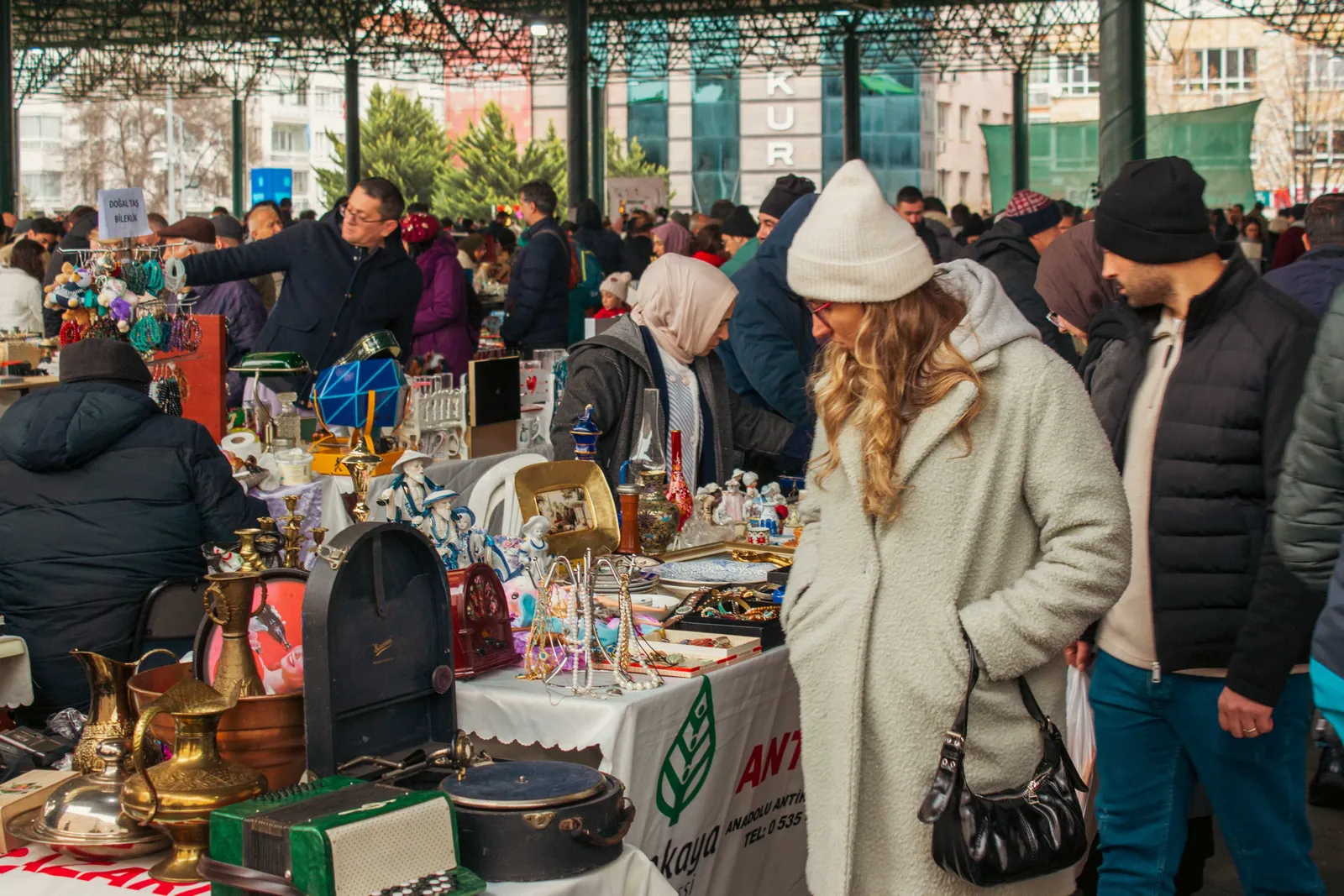 Shoppers browsing stalls at a busy outdoor market in Madrid, Spain