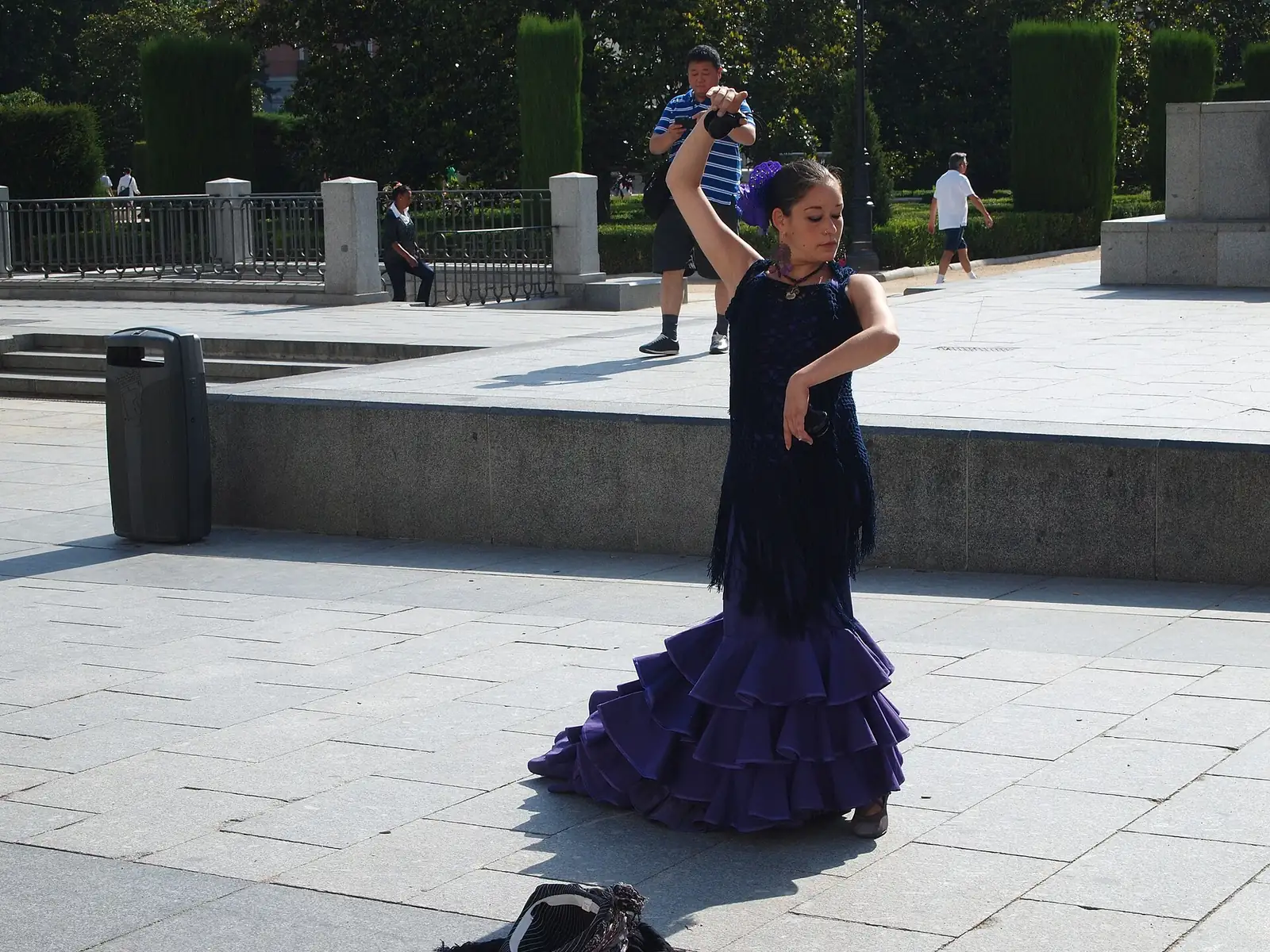 A young dancer in a flamenco dress performing on a paved street in Madrid, Spain