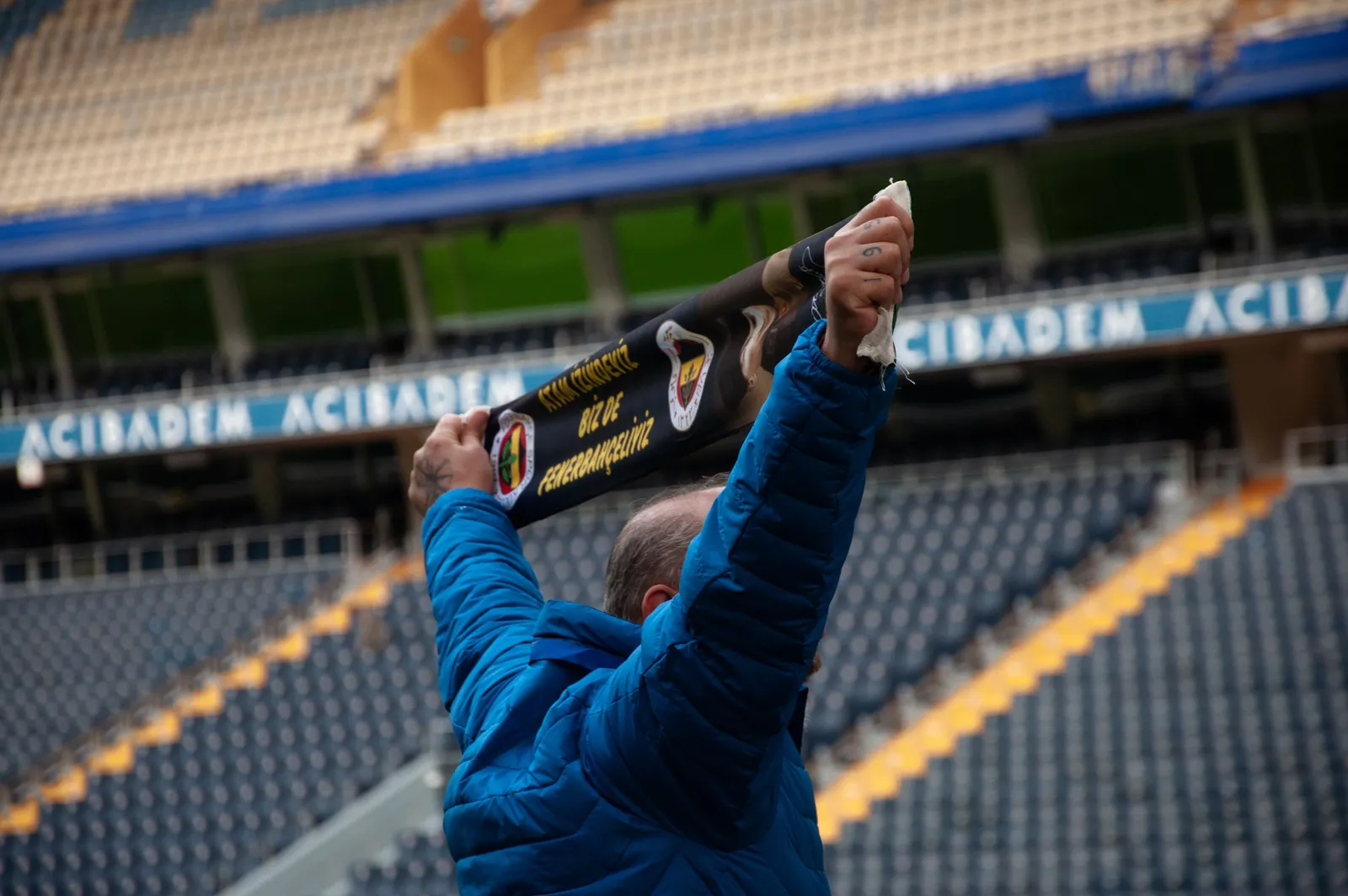 A supporter holding a scarf above the stands at a football match in Madrid, Spain