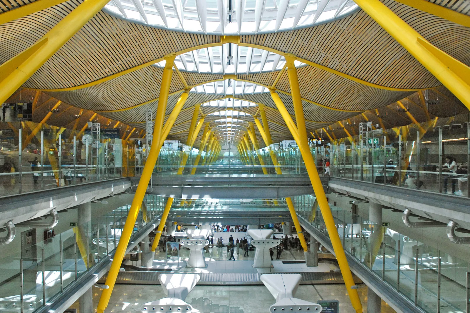 The wide interior hall and yellow supports of Terminal 4 at Madrid Barajas airport in Spain