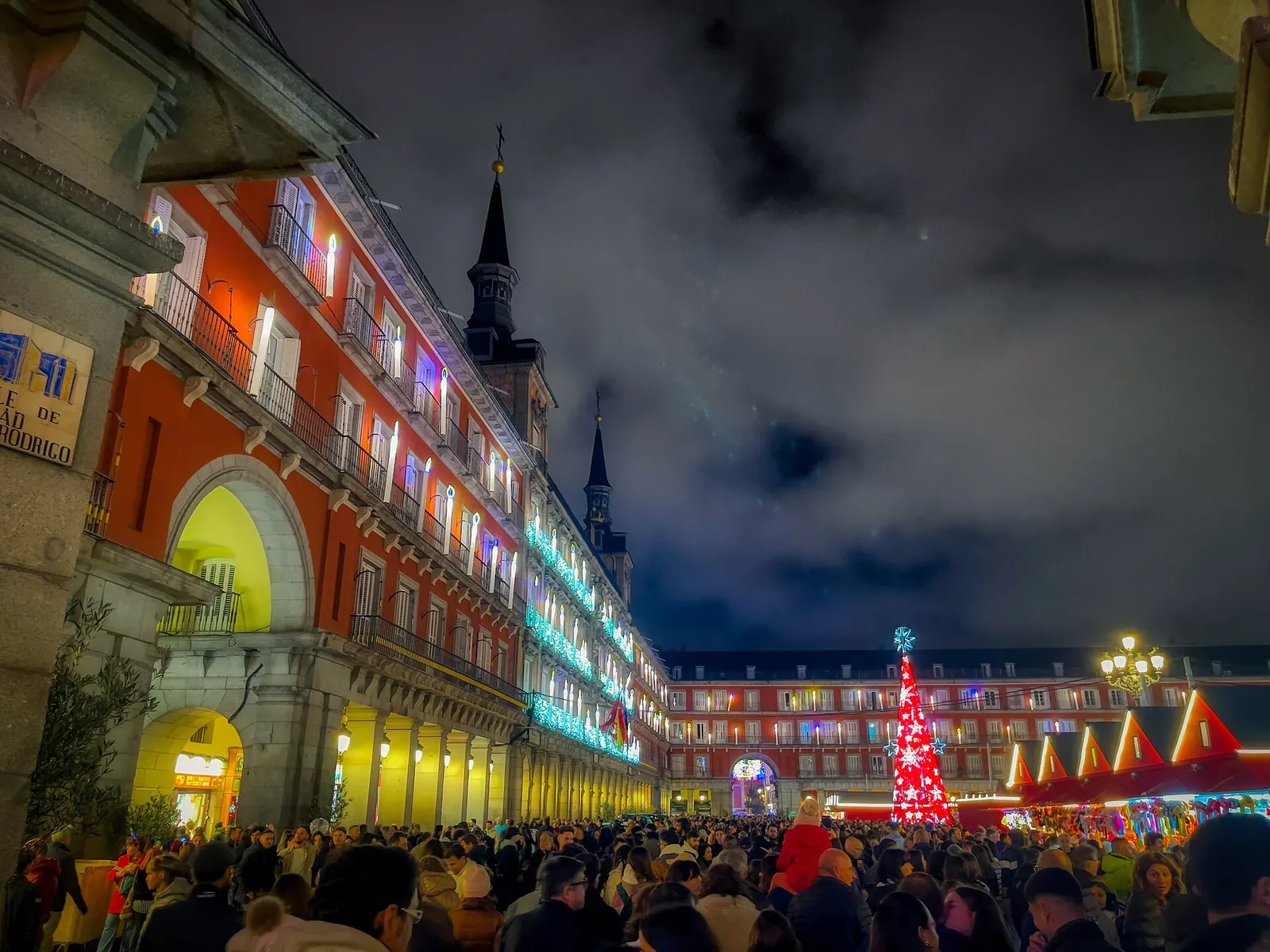 Crowds under the lit-up arcades and Christmas tree at the Plaza Mayor market in Madrid in December