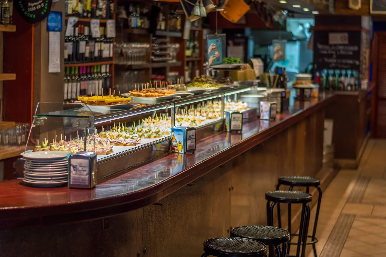 A bar counter lined with small tapas on bread in Madrid, Spain