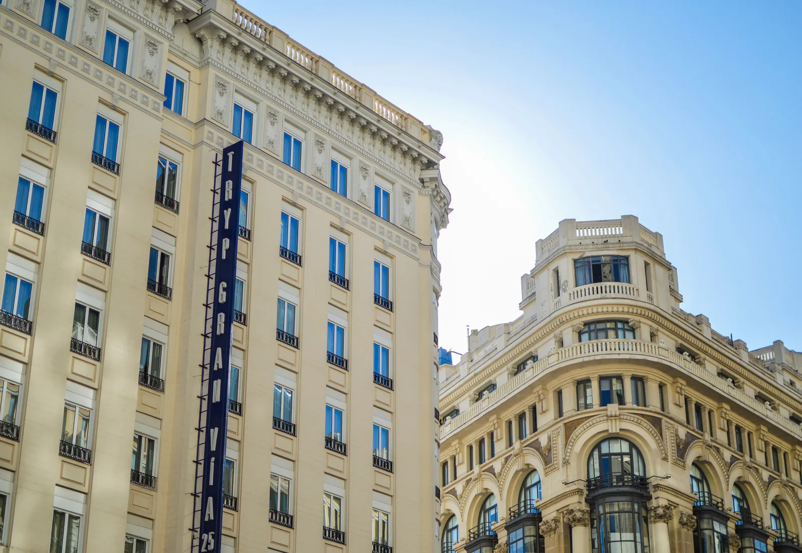 Hotel and apartment facades along Gran Via with a vertical hotel sign, Madrid, Spain