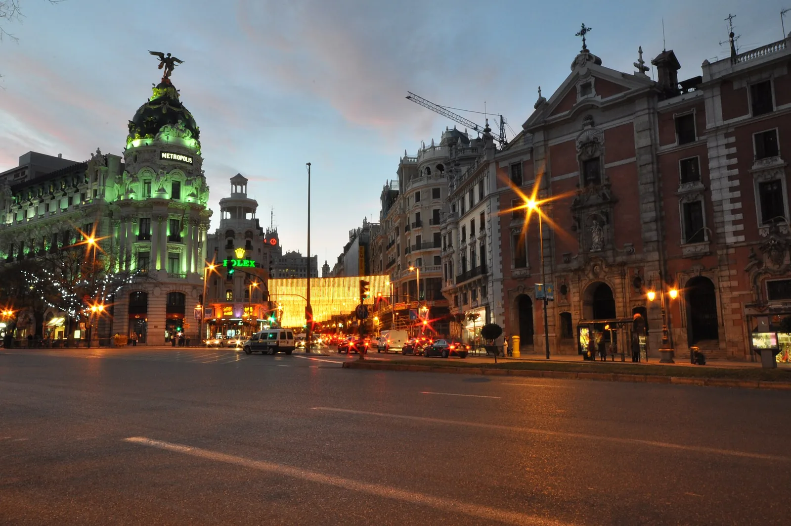 The illuminated Metropolis building on Gran Via at dusk in Madrid, Spain