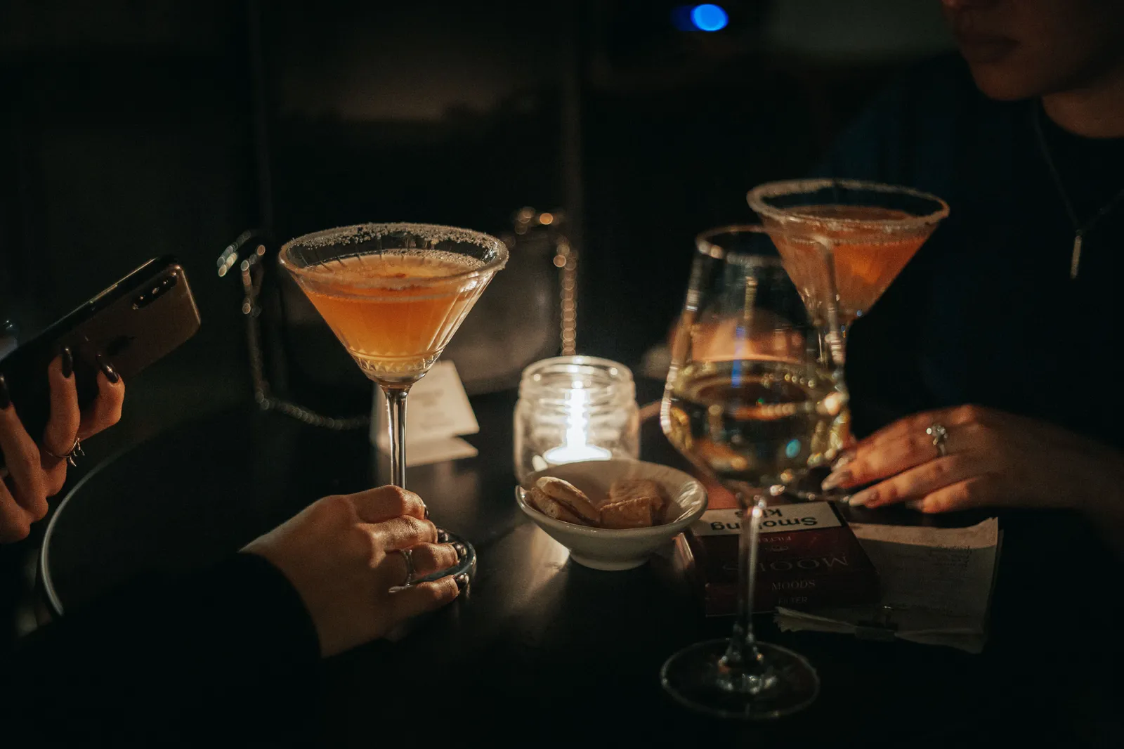 Cocktails on a bar counter in a dimly lit bar in Madrid, Spain
