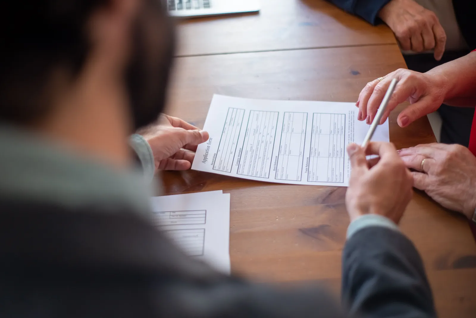 Two people going through an insurance application form at a desk