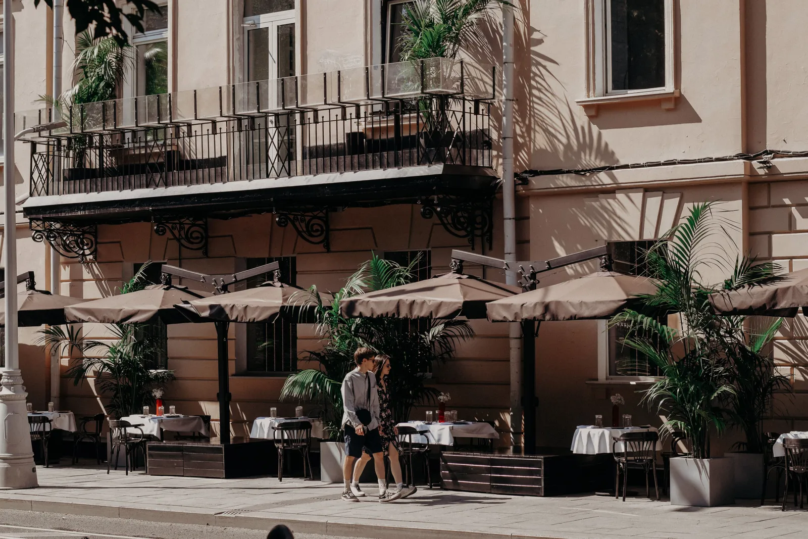 A shaded terrace in central Madrid during a hot summer afternoon with awnings drawn over the tables, Spain