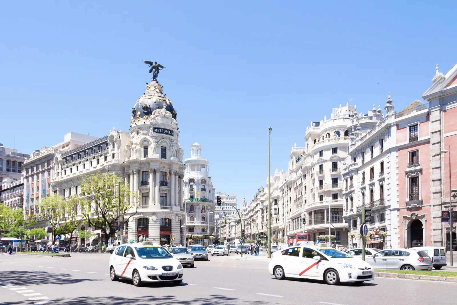 Taxis and traffic on Gran Via below the Metropolis building in Madrid, Spain