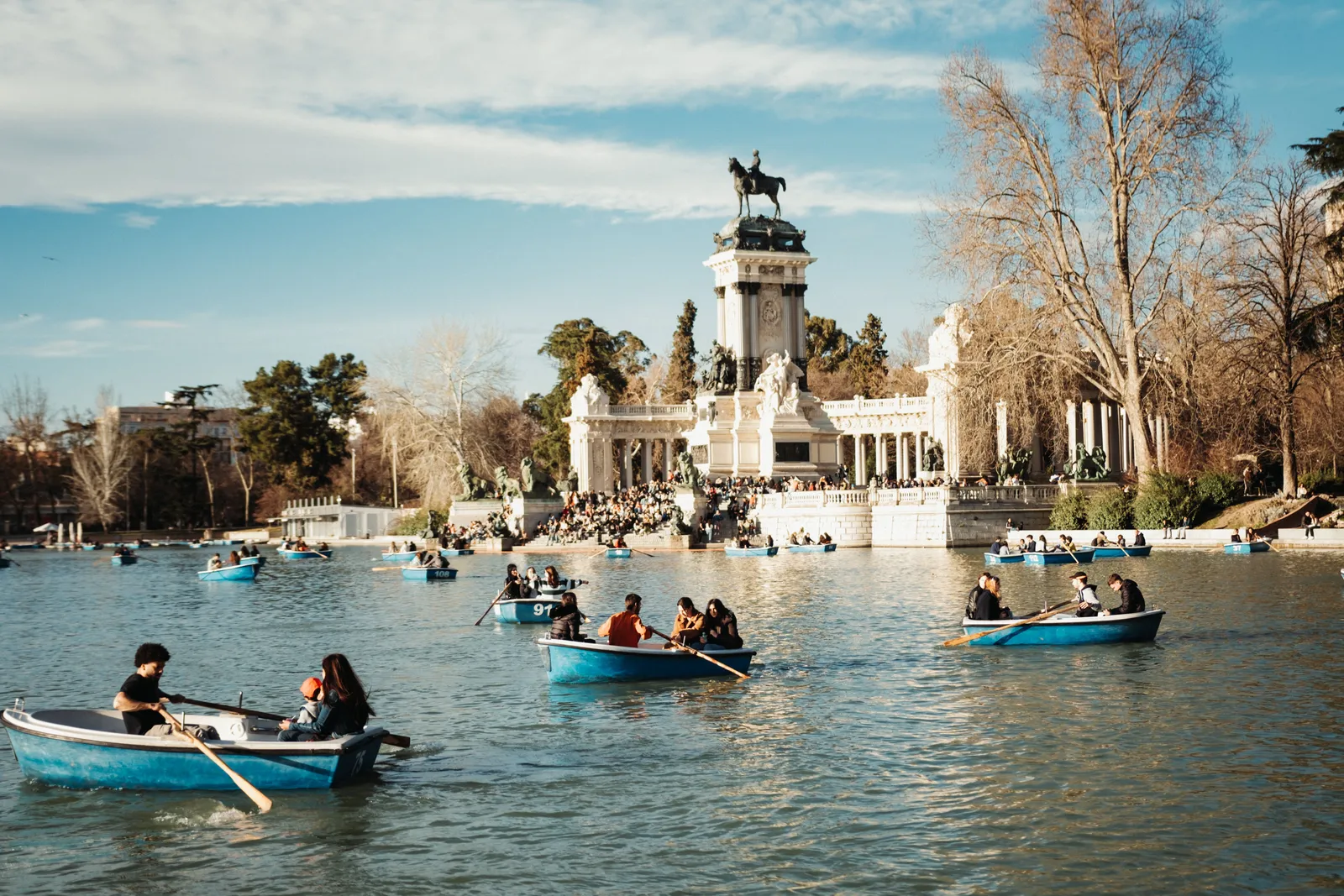 Rowing boats on the lake in the Retiro park with the Alfonso XII monument behind, Madrid, Spain