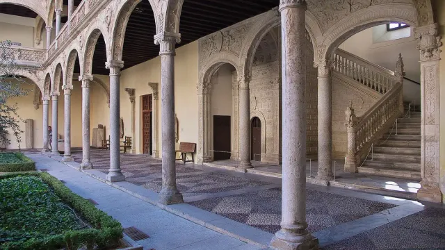 A Renaissance courtyard with arches, carved stone columns and a broad staircase