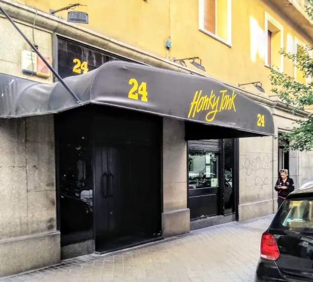 A black awning with yellow lettering above a dark entrance in a yellow building