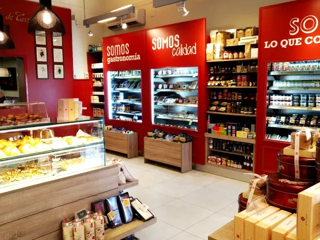 A shop interior with red walls, a pastry display case and shelves full of packaged boxes