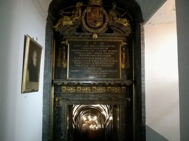 A gold and dark marble doorway with lit steps descending into an underground chamber