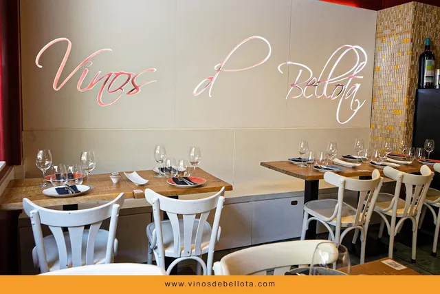 Set wooden tables with white chairs and illuminated lettering on the wall