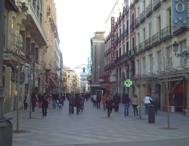 A narrow pedestrian street with shops, lanterns and historic buildings on both sides