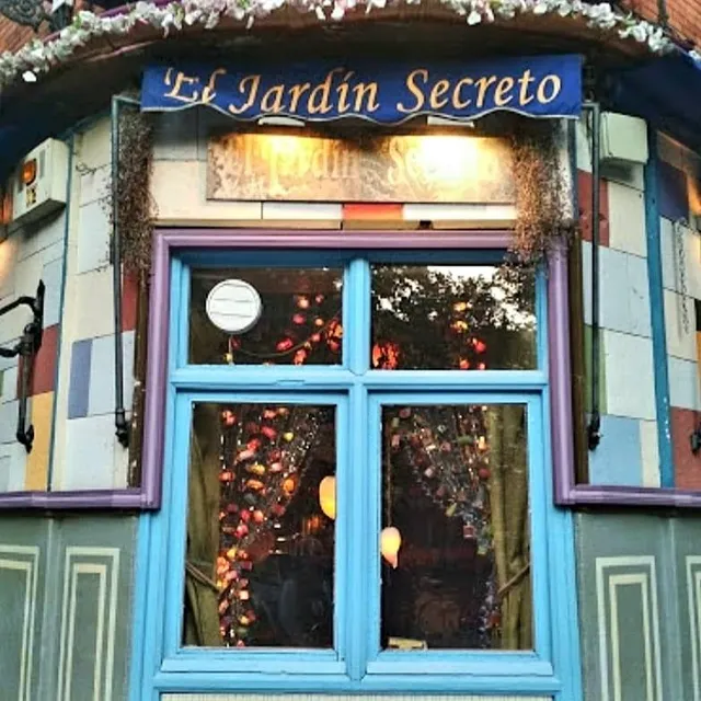 A colorful facade with a light blue window and warm lights visible inside