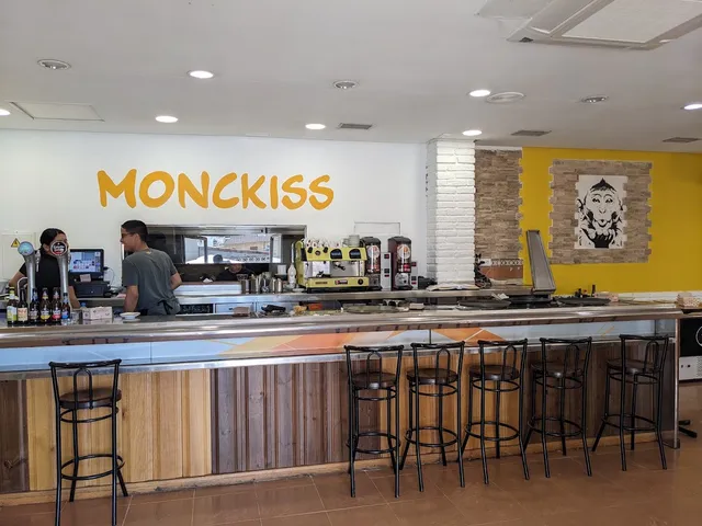 A long counter with high stools and the venue's name in yellow letters on the wall
