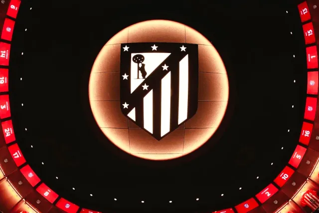 A lit club crest on a dark ceiling, surrounded by a red ring of numbers