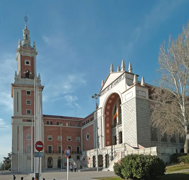 A red brick museum building with a tall bell tower and an arcaded front