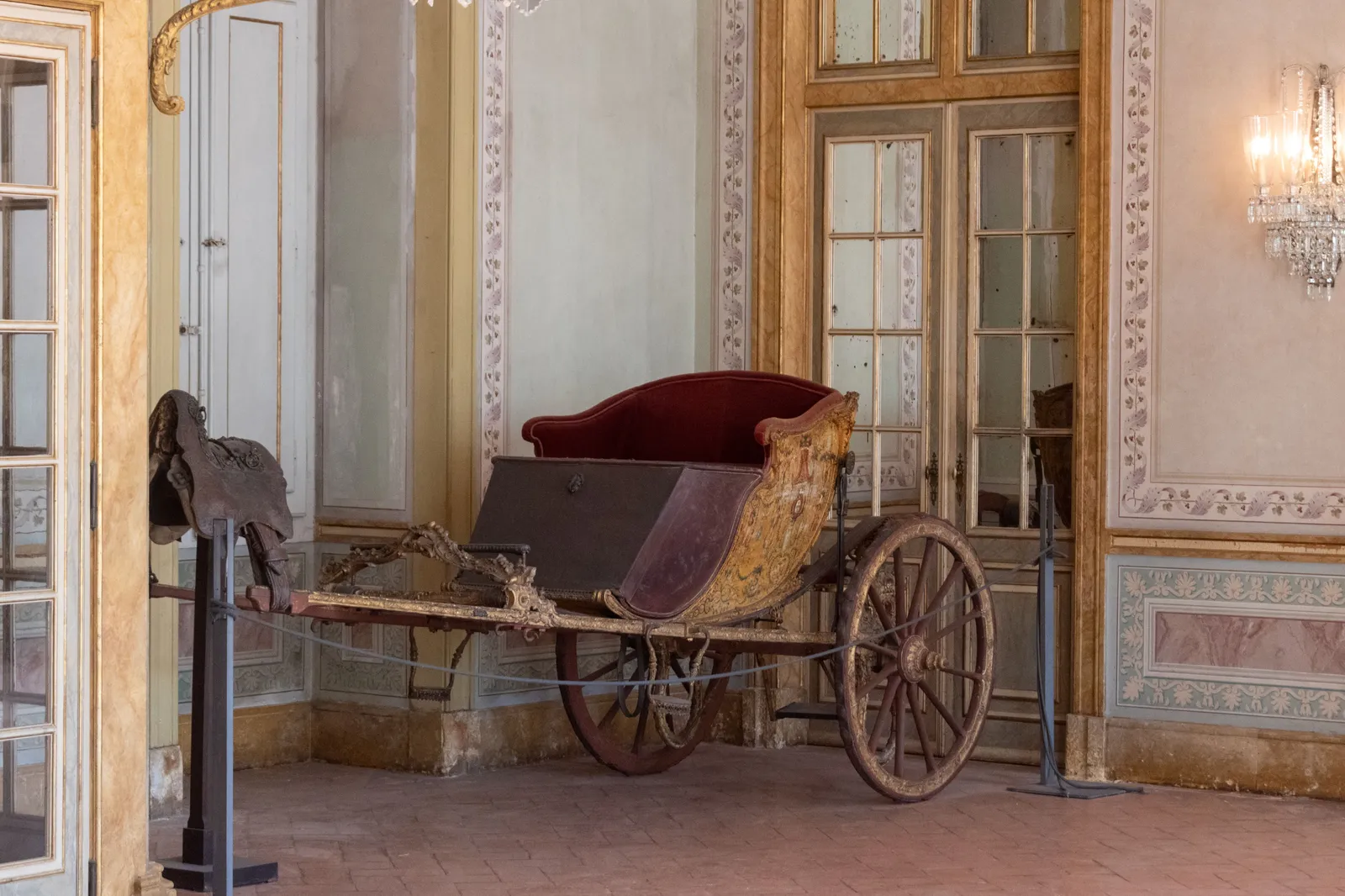 An antique wooden cart displayed inside a historic building interior