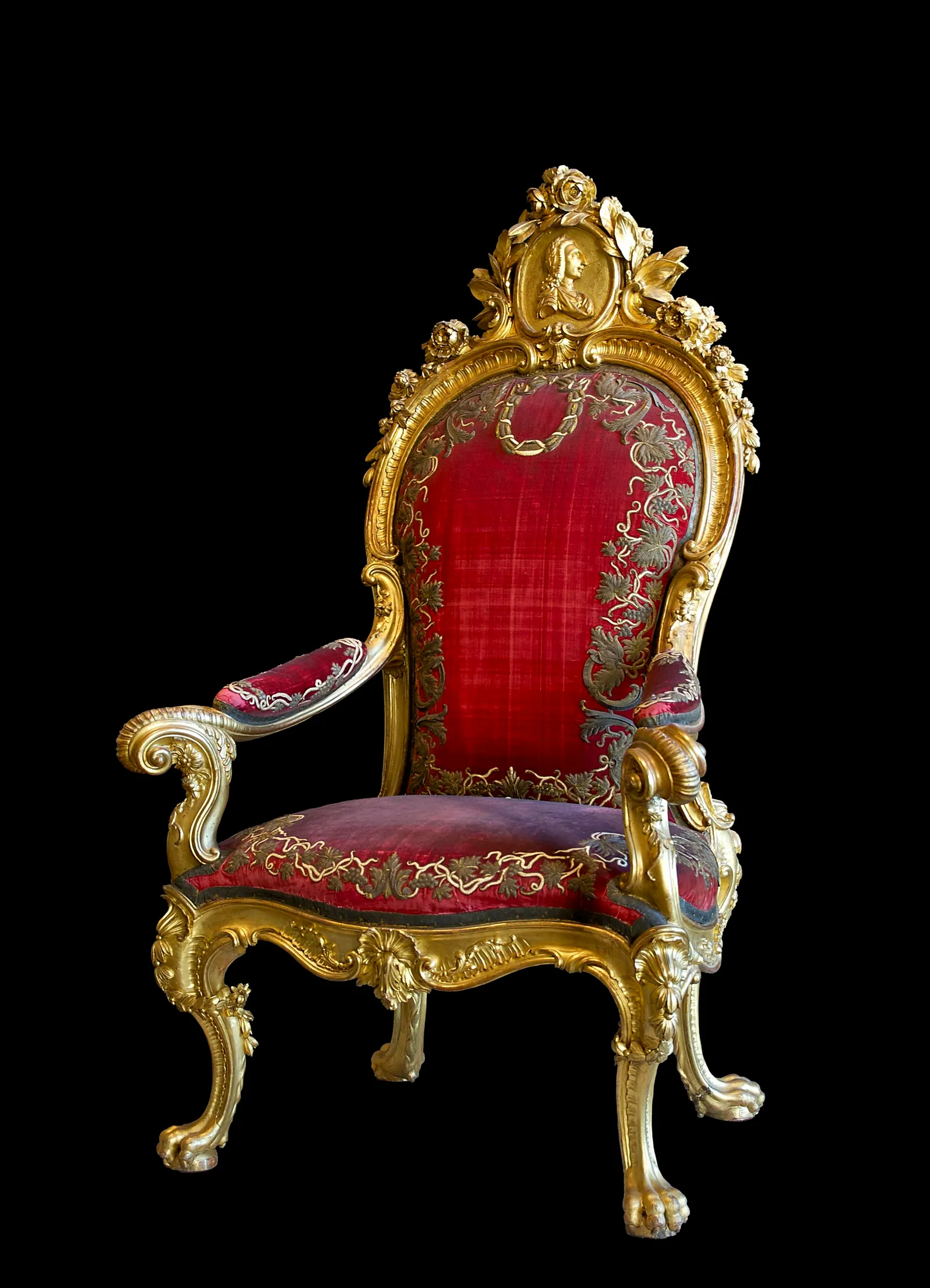 The gilded throne and crimson-draped walls of a state room in the Royal Palace of Madrid, Spain