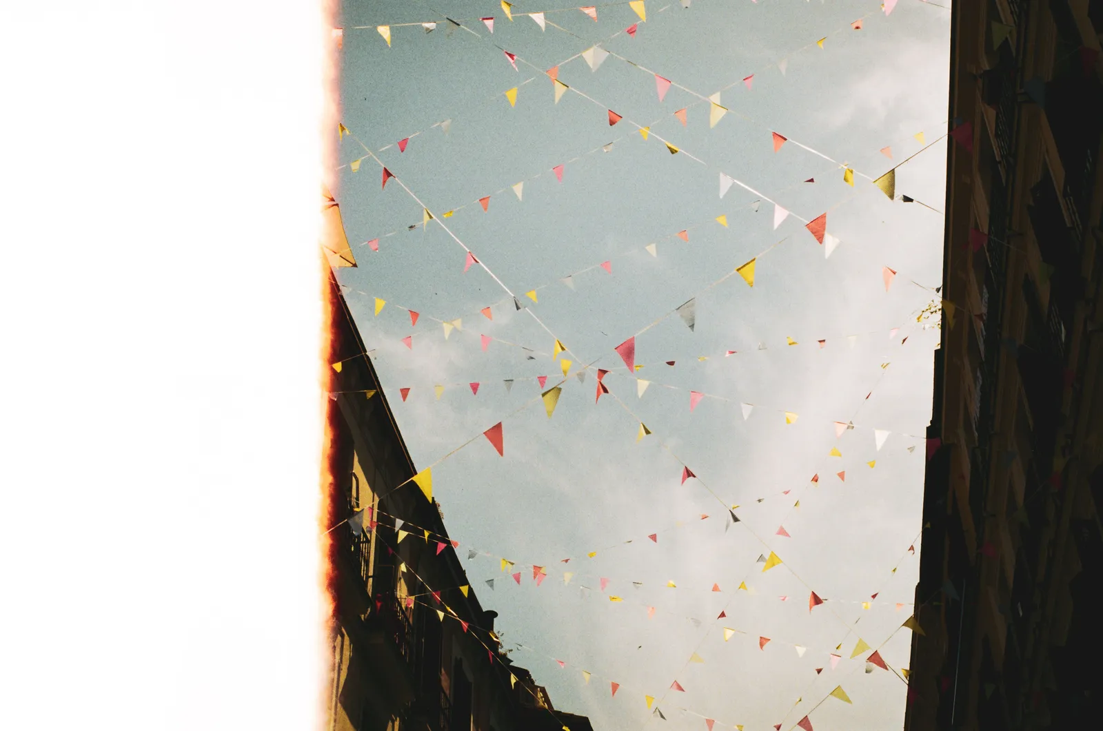 Festival bunting and paper decorations strung above a street in Madrid, Spain