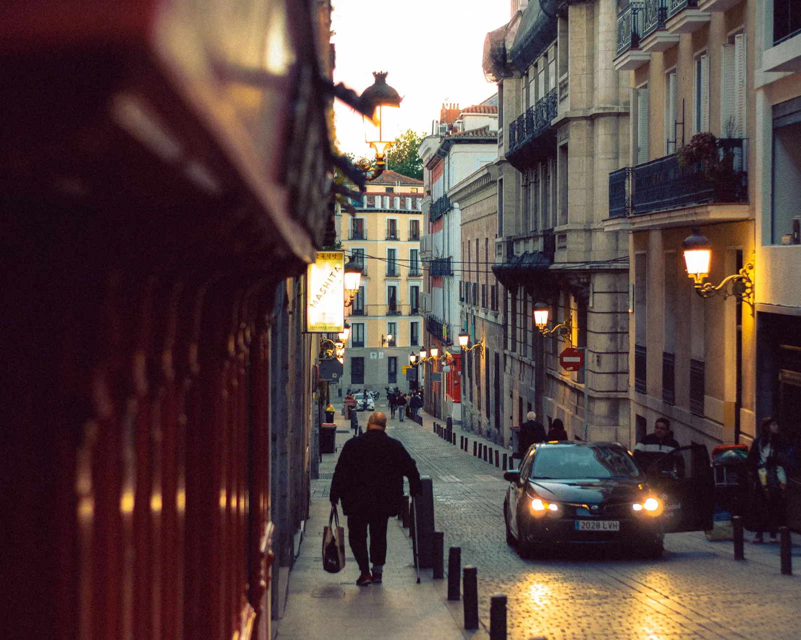 A shopper walking through an arcade of shops in Madrid, Spain