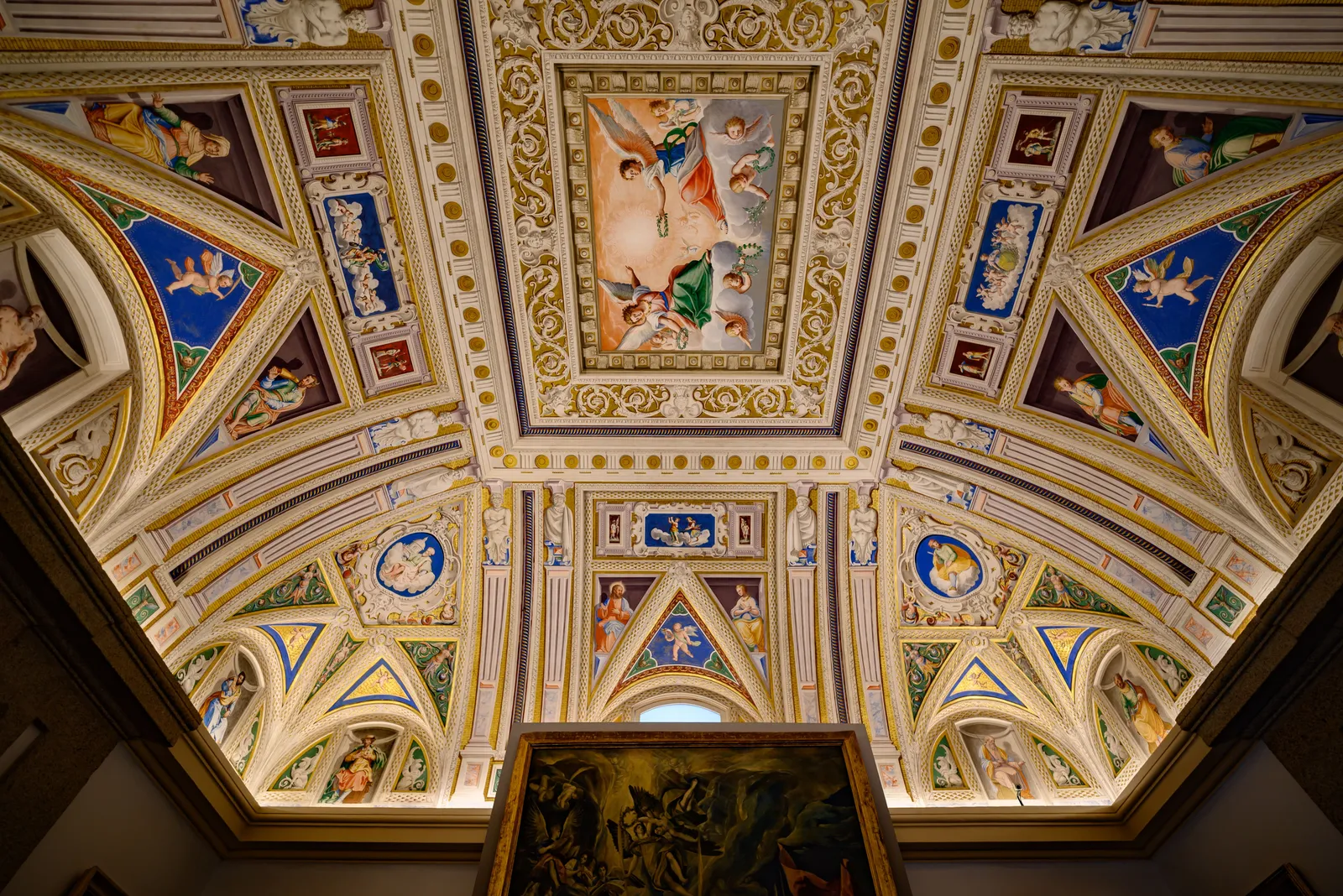 Visitors looking at early Renaissance panel paintings in a museum gallery in Madrid, Spain