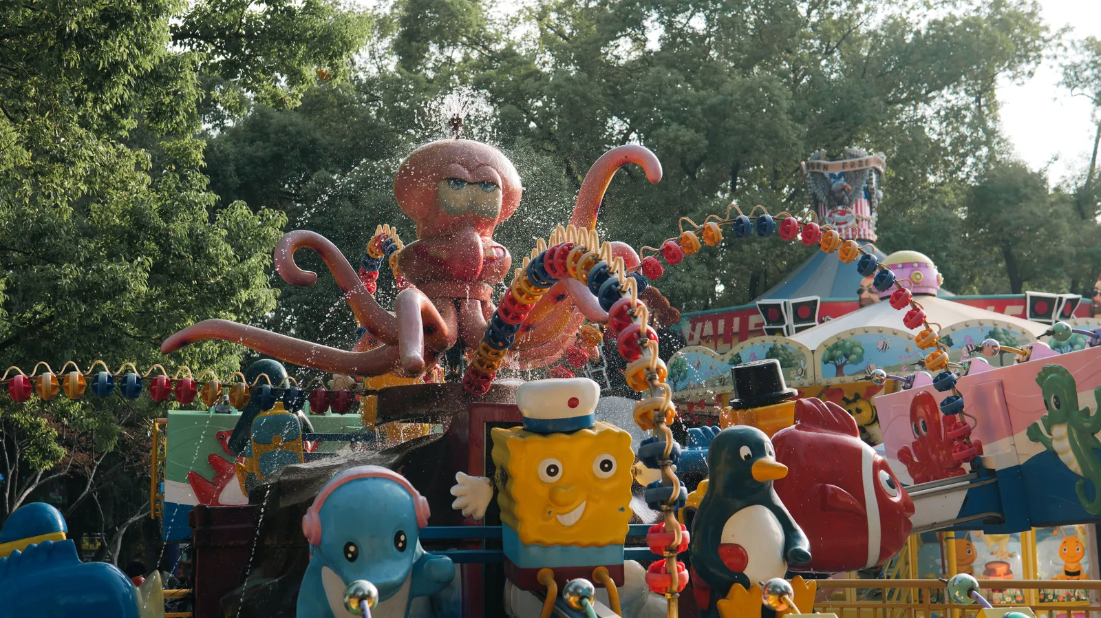 A brightly coloured family ride themed to cartoon characters in a children's area of a theme park, Spain